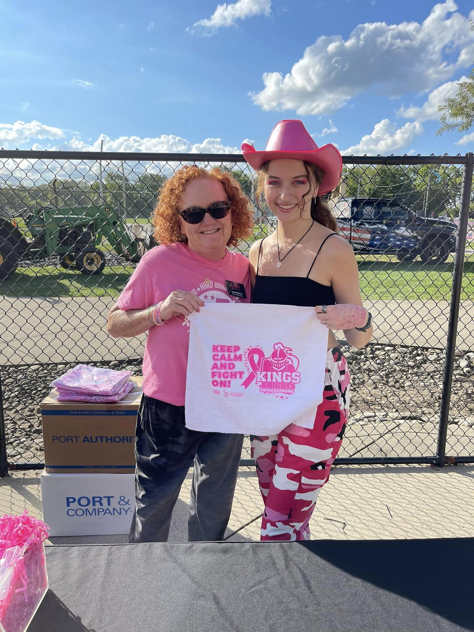 Women posing holding a breast cancer awareness fight towel 